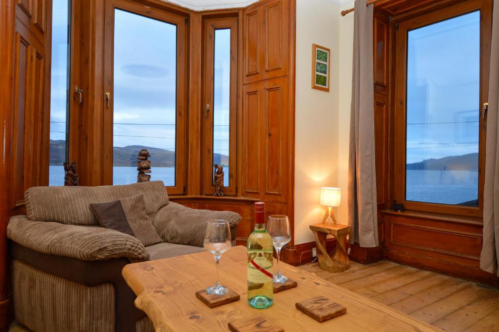 a living room with a couch and a table at Secret Coast Getaway in Tighnabruaich