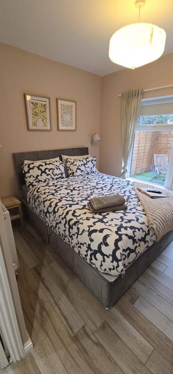 a bedroom with a bed with a black and white comforter at Lawson Lodge in Alveston