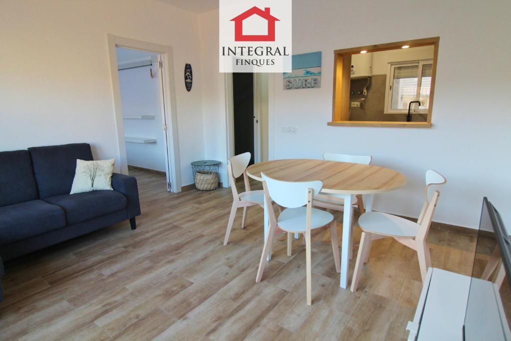 a living room with a table and chairs and a couch at Apartament Marea Alta in San Juan de Palamós