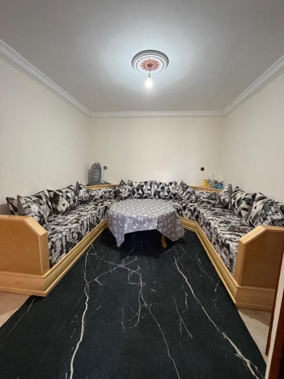 a living room with a large couch with a table at Samadis Home 2 in Larache