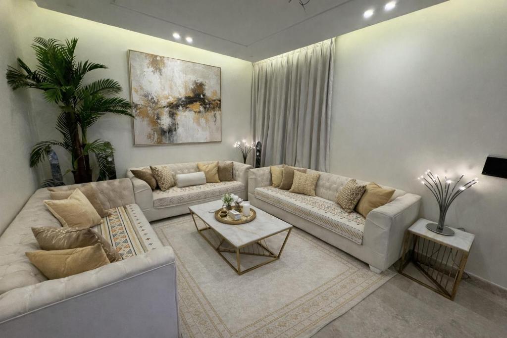 a living room with two couches and a table at AL Rayan Luxury Apartments in Jeddah