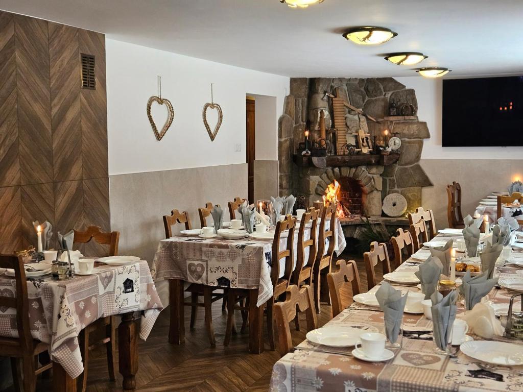 a restaurant with tables and chairs and a fireplace at Willa Litworówka in Biały Dunajec