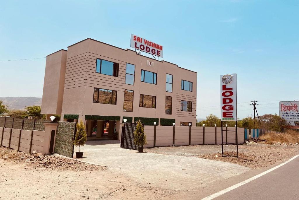 a building with a sign for a hotel at Sai Vishwa Lodging in Pune