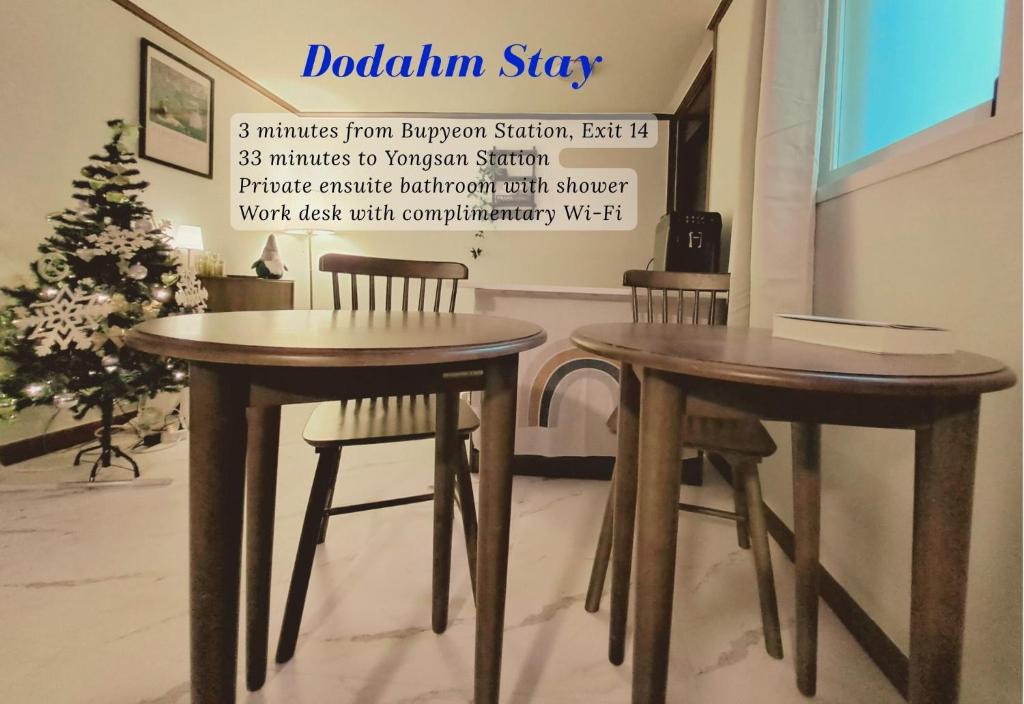 two tables and chairs in a room with a christmas tree at Dodahm guesthouse stay in Incheon