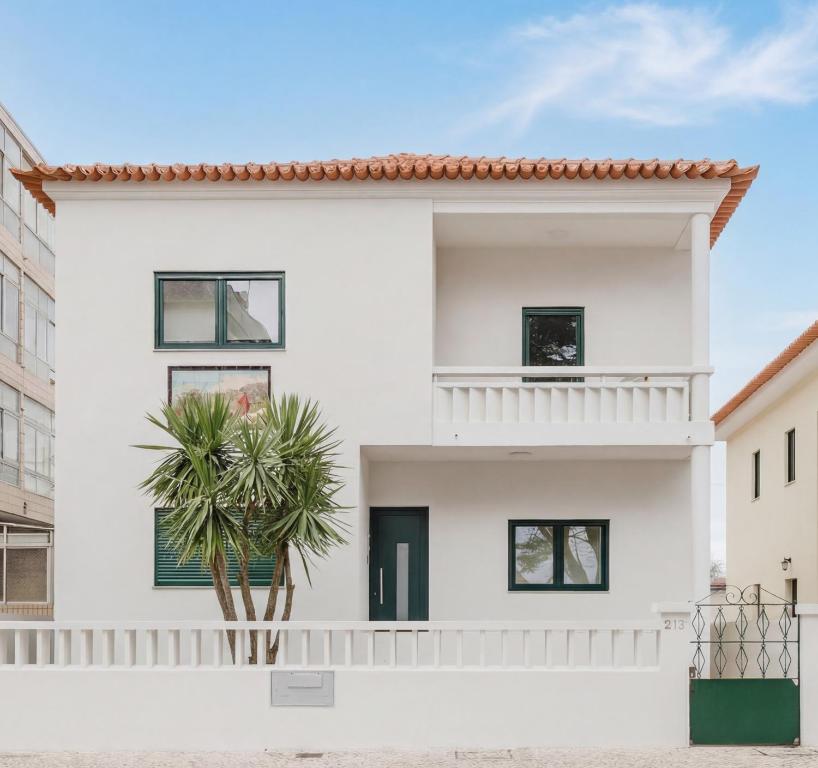 a white house with black windows and a palm tree at Póvoa Studios by Pomerania in Póvoa de Varzim