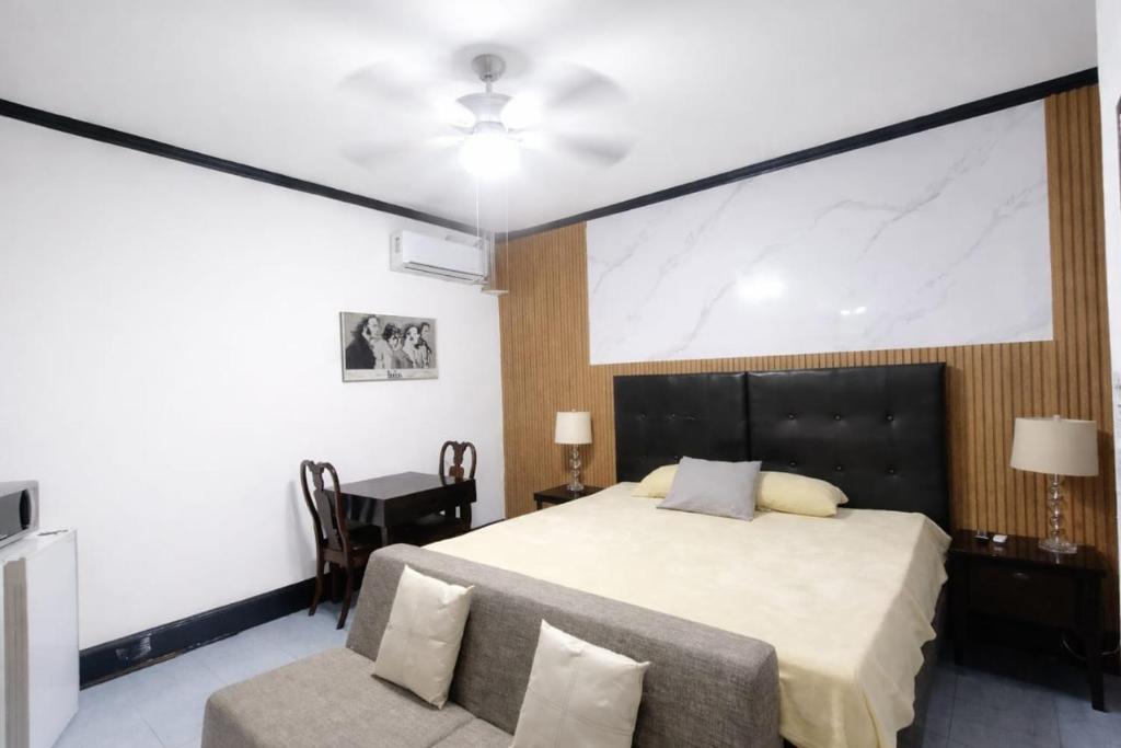 a bedroom with a large bed and a chair at Hotel Garcias Suites, Linares in Linares