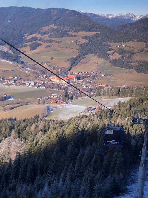 a gondola flying over a town in the mountains at Ferienwohnung Alexanderhof in Sankt Lambrecht