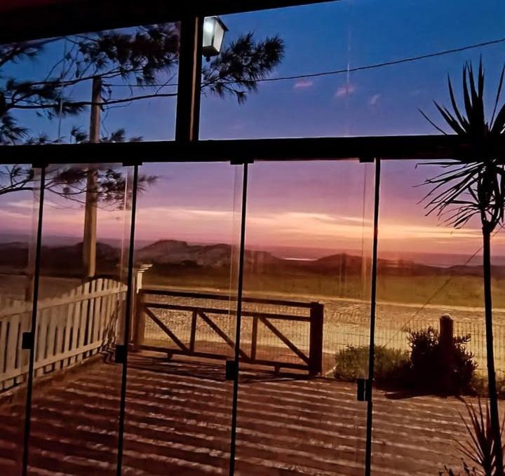 a view of a sunset through a glass window at Beira Mar in Tramandaí
