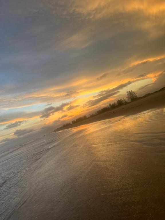 a sunset over a body of water with the sky at Casa ilha comprida perto da praia in Ilha Comprida