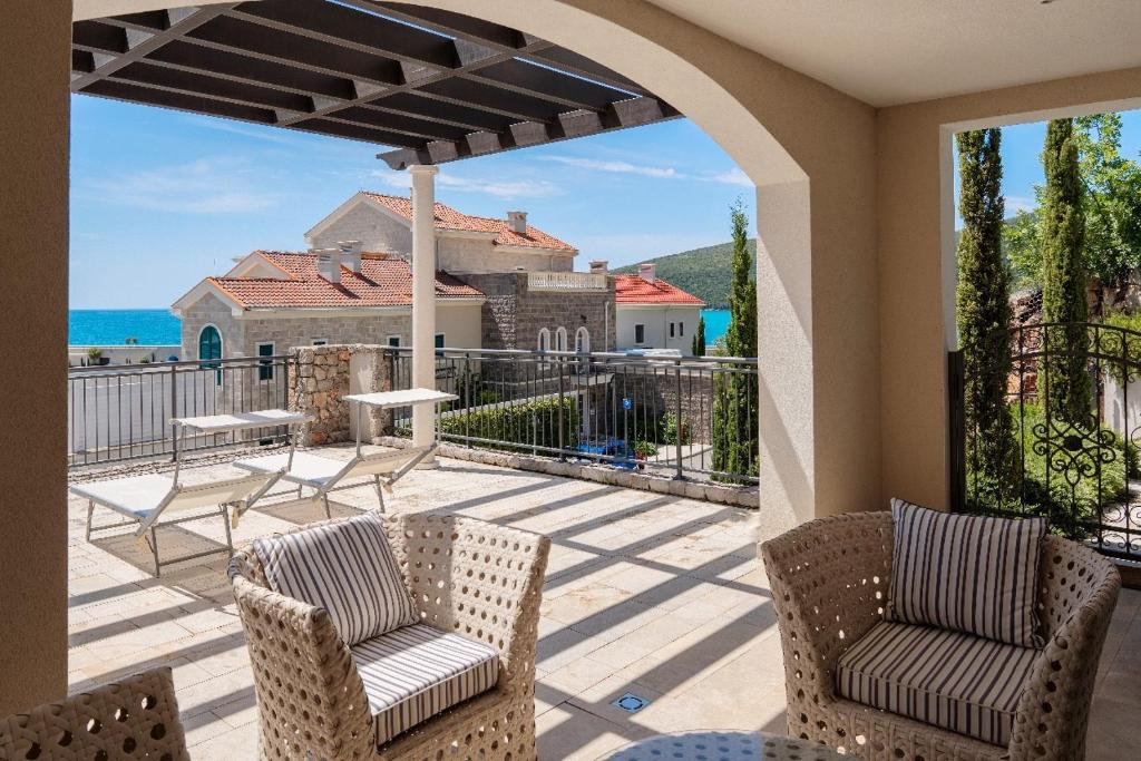 a patio with chairs and a view of the ocean at Lustica-Marina GOLD APARTMAN in Radovici