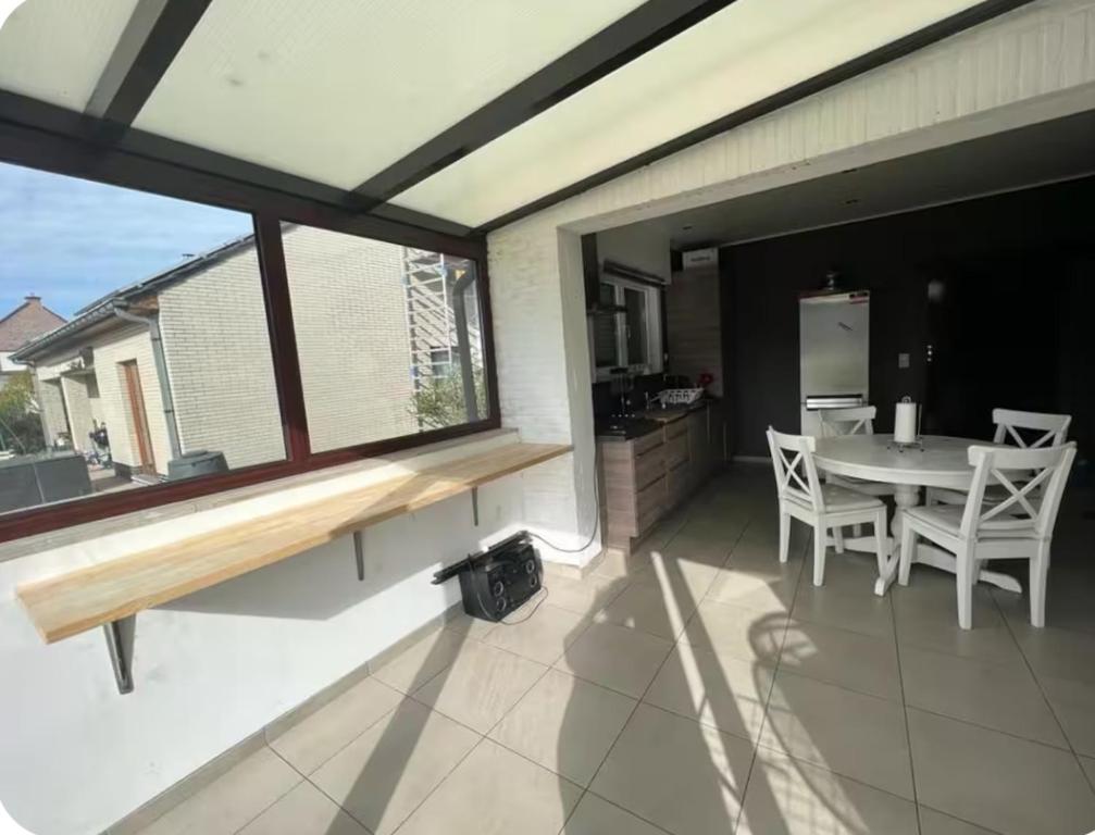 a patio with a table and chairs and a kitchen at Dar Fouad in Vilvoorde