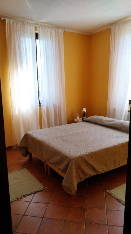 a bedroom with a large bed with white curtains at Tenuta Rio del Sole-Camera doppia in Albairate