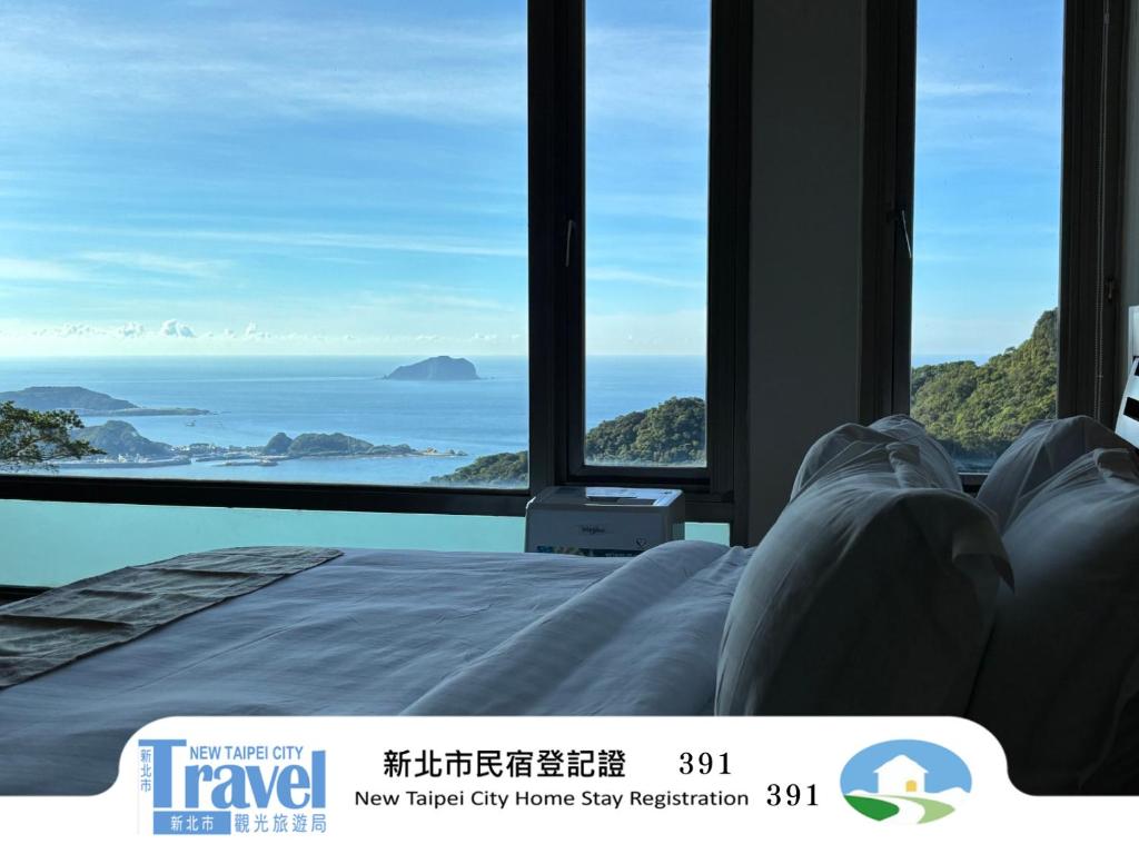 a bed in a room with a view of the ocean at 隱山居 海景包棟2-10人 in Jiufen