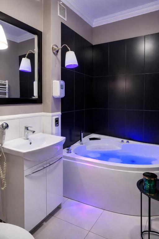 a bathroom with a white tub and a sink at EUROPA22 Apartament z JACUZZI w samym sercu miasta Tomaszów Maz - balkon z widokiem na park i fontanny Szybkie zameldowanie od 13 in Tomaszów Mazowiecki