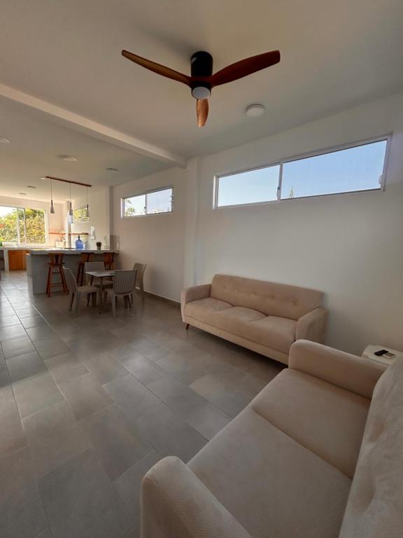 a living room with a couch and a ceiling fan at Almar in Olón