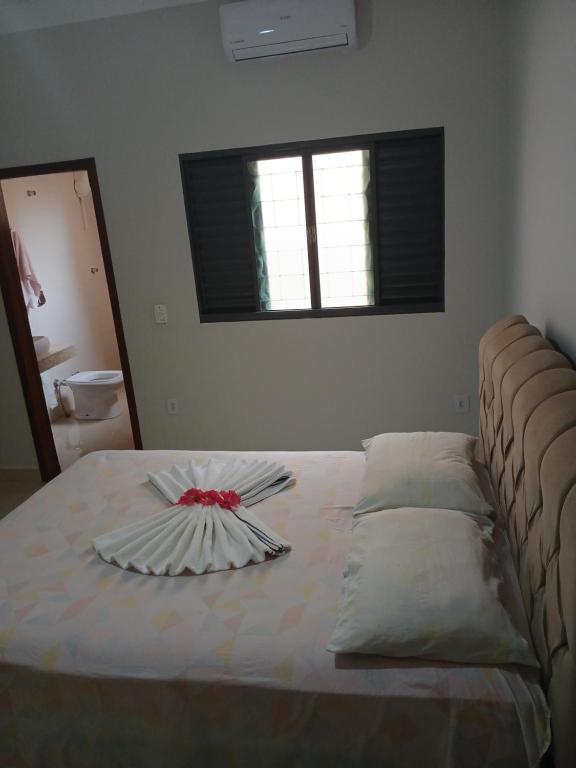 a bed with a plate on top of it at Quartos Festa do Peão Barretos in Barretos