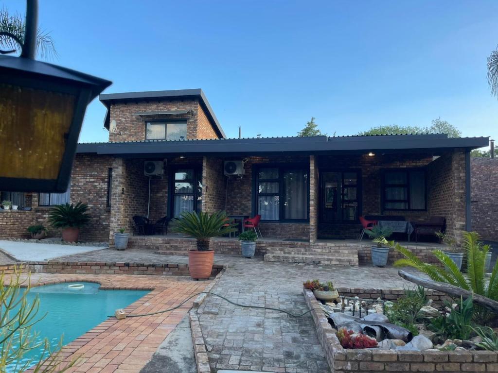 a brick house with a pool in front of it at Luigi's Place in Pretoria