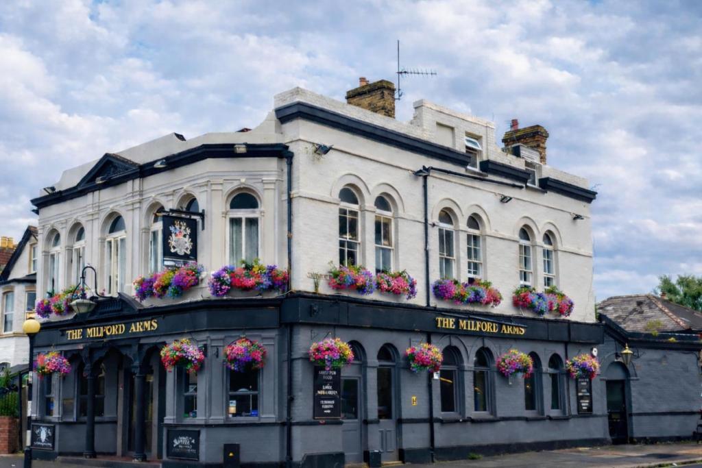 a white building with flower boxes on the front at The Milford Arms in Hounslow