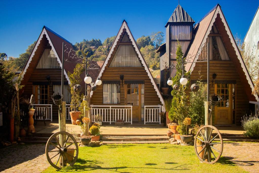 a log cabin with two large wheels in front of it at Altaroma - Pousada e Experiência Gastronômica in Campos do Jordão