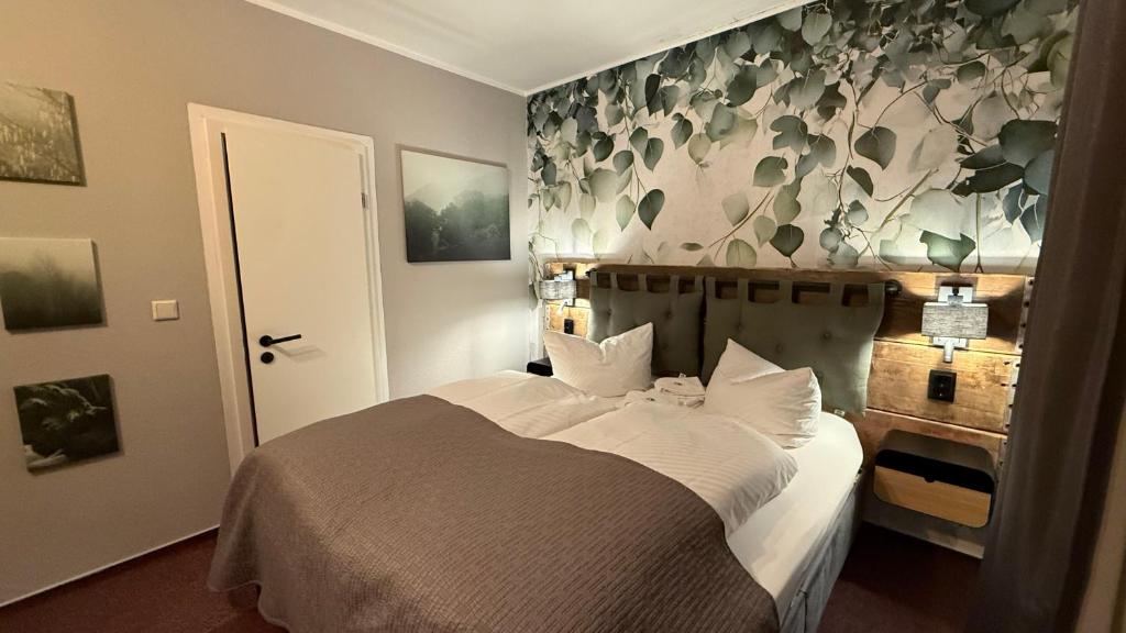 sypialnia z łóżkiem i ścianą w kwiaty w obiekcie Hotel Annablick w mieście Strausberg