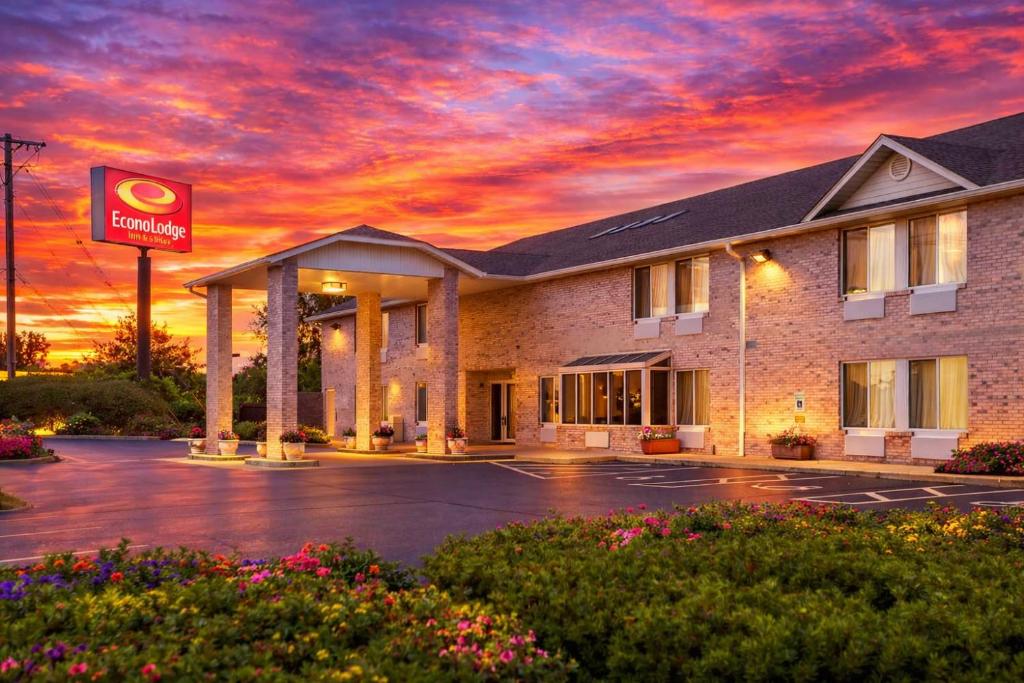 a hotel with a sunset in a parking lot at Econo Lodge Inn & Suites Fairview Heights St Louis in Fairview Heights