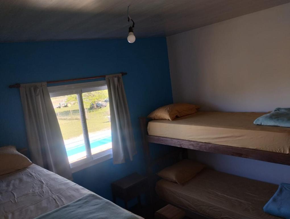a bedroom with two bunk beds and a window at Cabaña gio in Potrero de Garay
