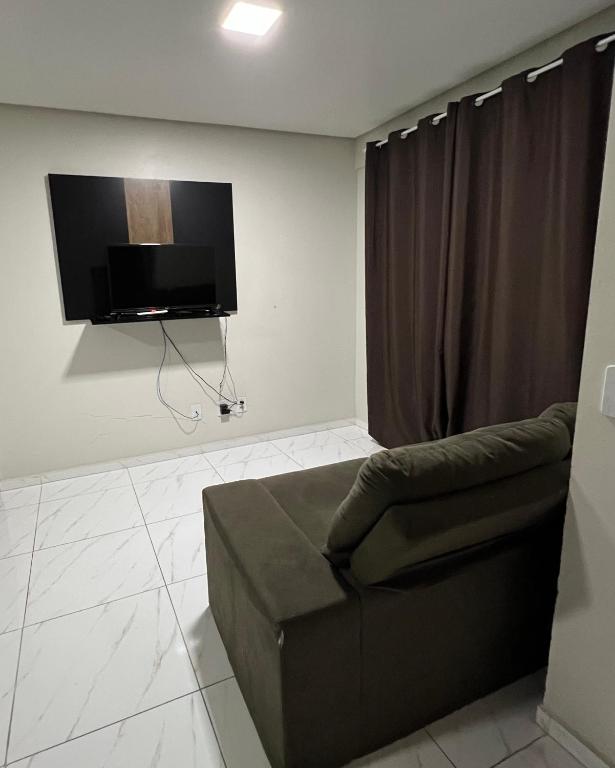 a living room with a couch and a flat screen tv at Apartamento em Pomerode - 203 in Pomerode