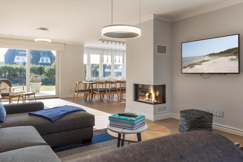 a living room with two couches and a fireplace at Sylter Inselglück in Wenningstedt