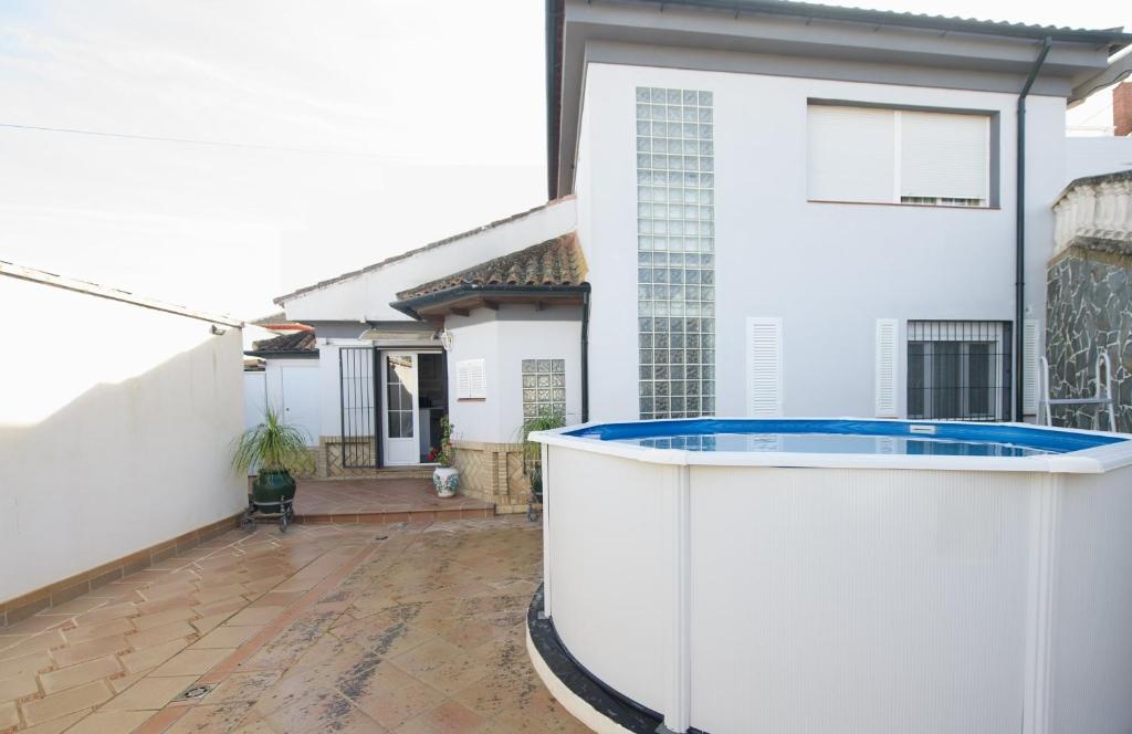 a white house with a swimming pool on a patio at Apartamentos turísticos ilusiones in Cazalla de la Sierra