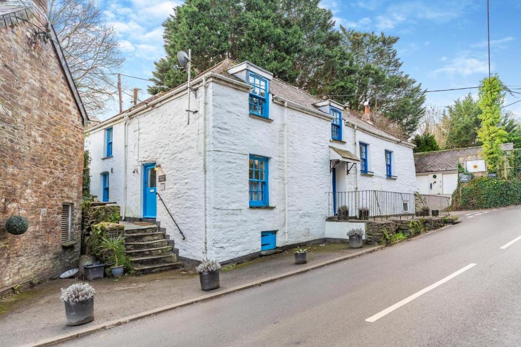 a white house with blue windows on a street at 2 Bed in Little Petherick oc-w28425 in Little Petherick