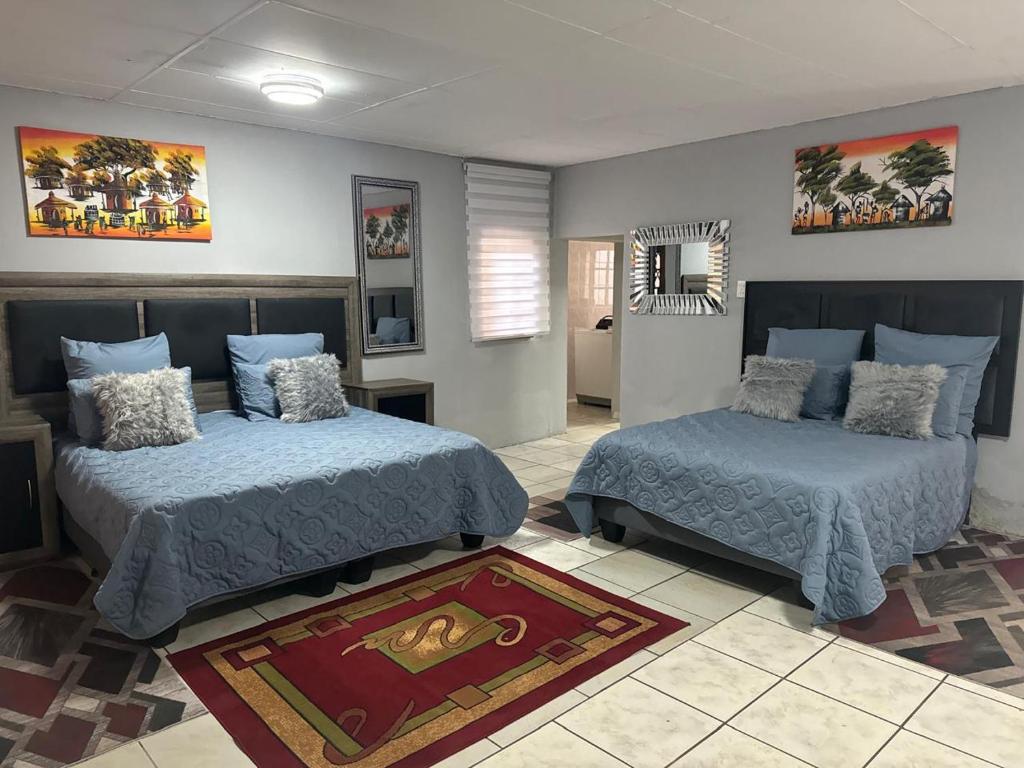 a bedroom with two beds and a mirror at Tana B Guesthouse in Welkom