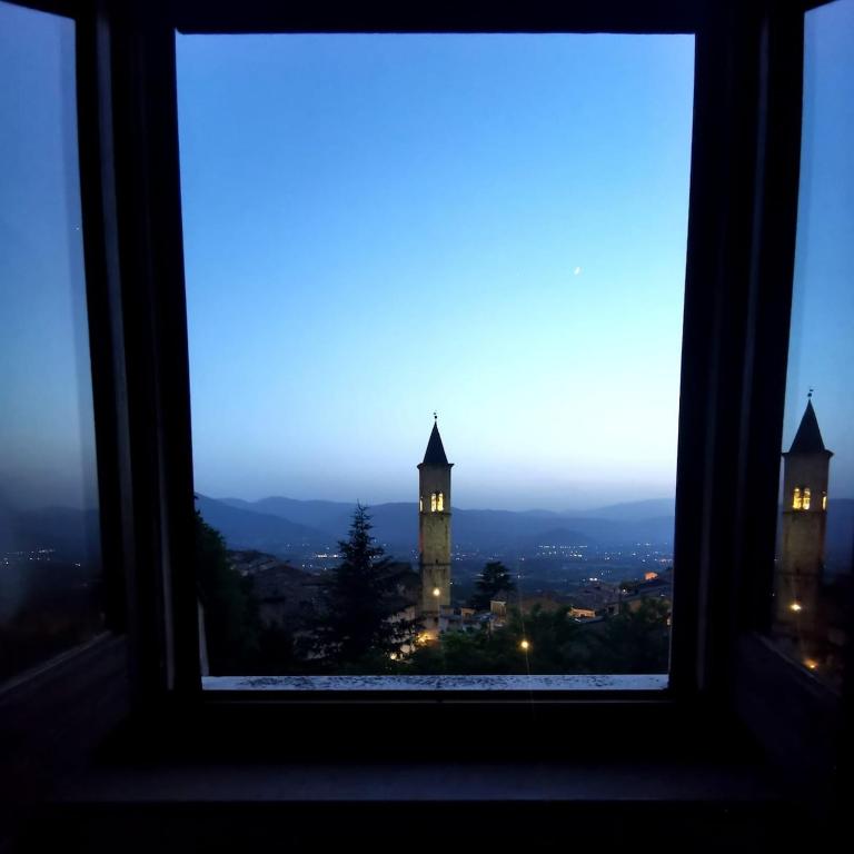 a view of a clock tower from a window at Sotto le 3 Torri in Pacentro