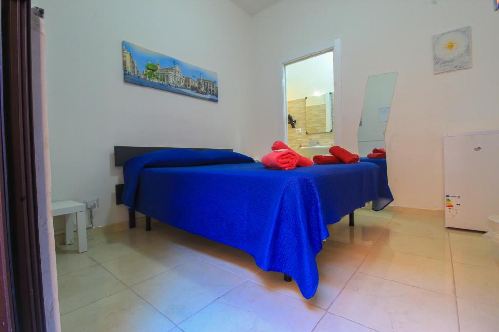 a bedroom with two beds with blue sheets and red pillows at bed and fly near 2 fontanarossa 800mt aeroporto catania in CTA
