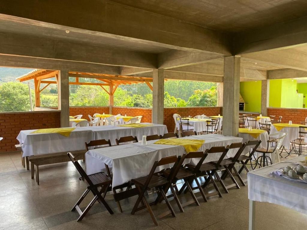 a dining room with white tables and chairs at Mountain View Guesthouse: Peaceful Retreat near Tiradentes in Prados