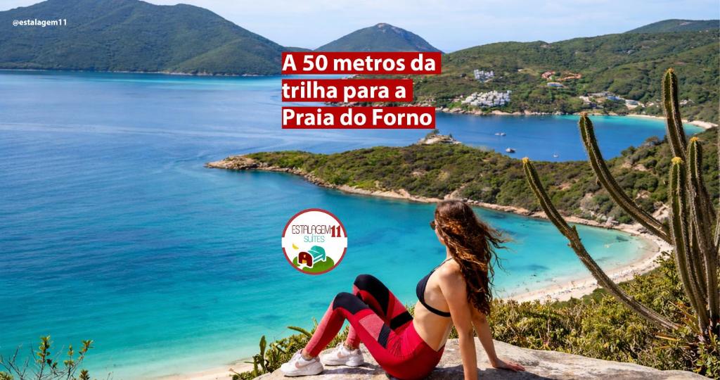 a woman sitting on a cliff looking at a beach at FLAT Estalagem 11 in Arraial do Cabo