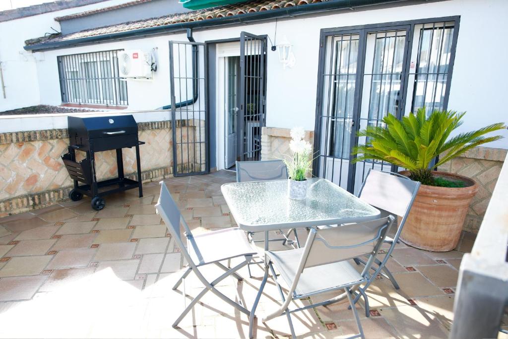 a patio with a table and chairs and a piano at Apartamento turísticos ilusiones 1 in Cazalla de la Sierra