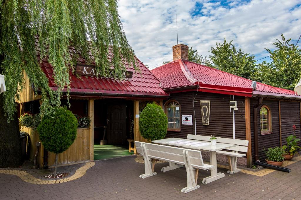a building with a picnic table in front of it at Karczma Pod Topolami in Ratowo Piotrowo