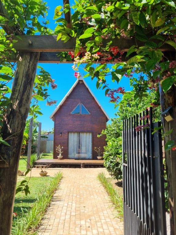 a wooden house with a gate and a brick driveway at Chalé SZ Pantanal in Cáceres