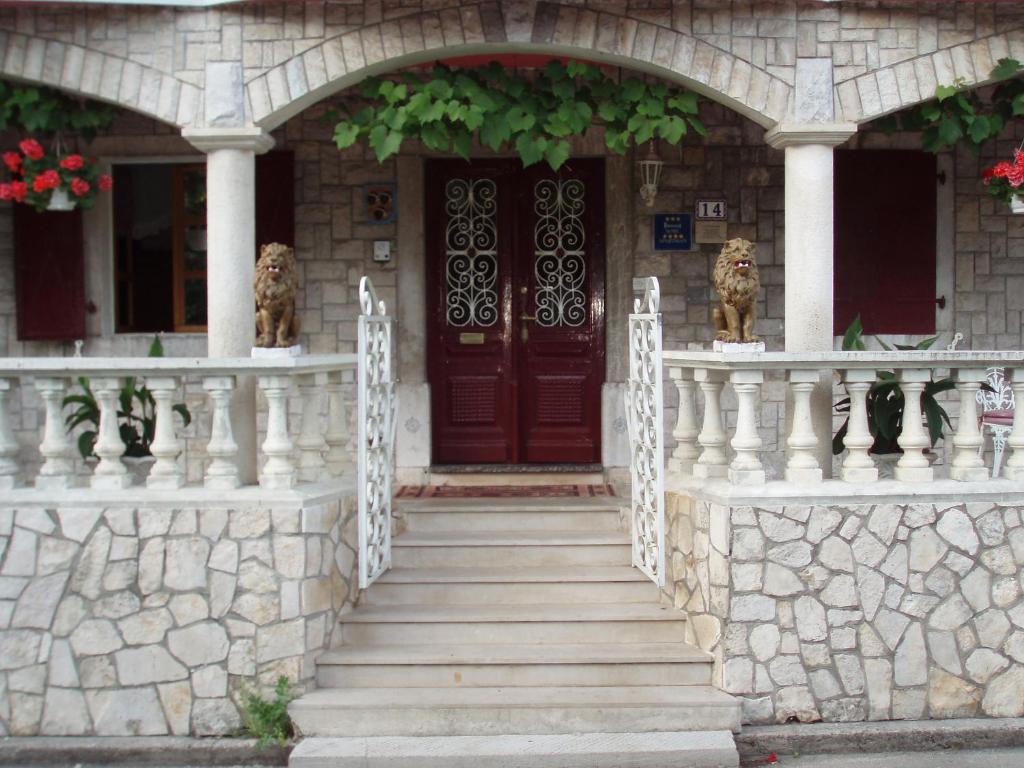 een huis met een trap naar een houten deur bij Apartments and Rooms Deskovic in Mošćenička Draga