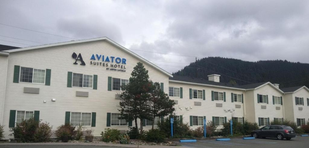 a large white building with a sign on it at Aviator Suites Hotel Juneau Airport by Aspen Hotels in Juneau