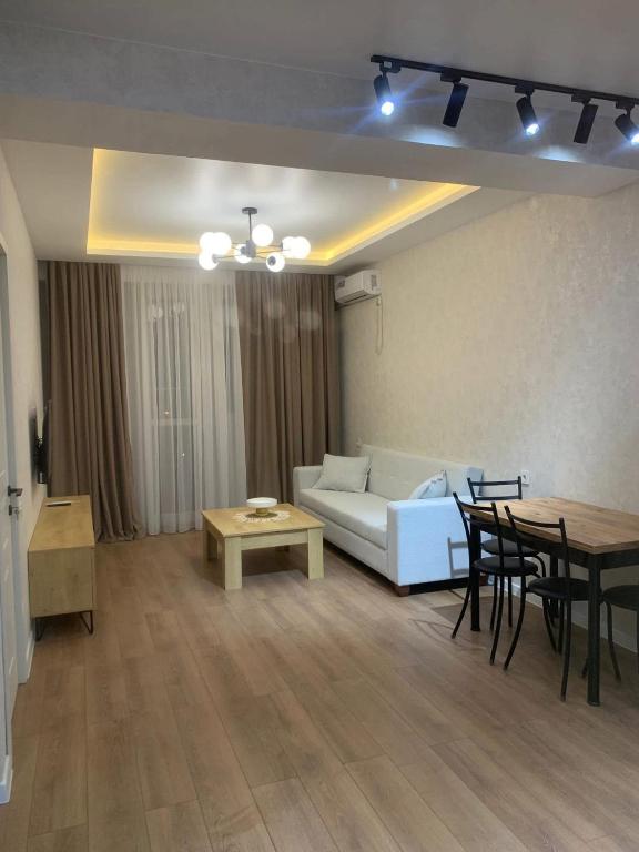 a living room with a white couch and a table at E&L Apartment tbilisi in Tbilisi City