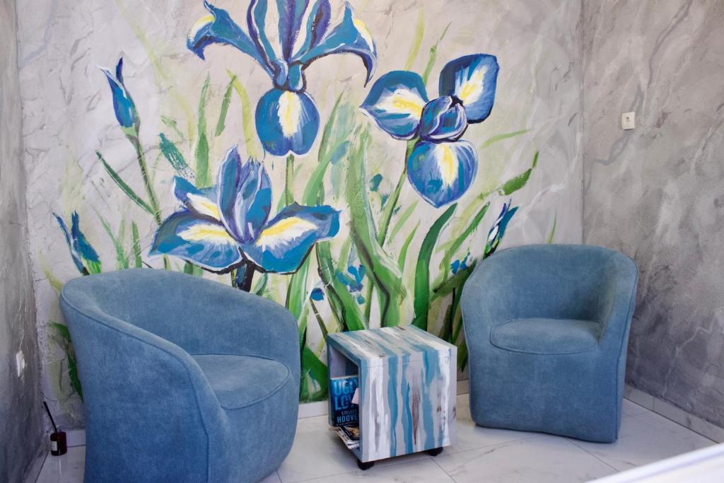 two blue chairs in front of a mural of blue flowers at Luxury Lidija Rooms in Split