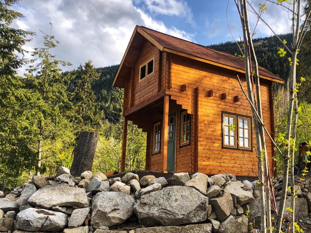 a log cabin behind a pile of rocks at Boho Bungalow in Nelson