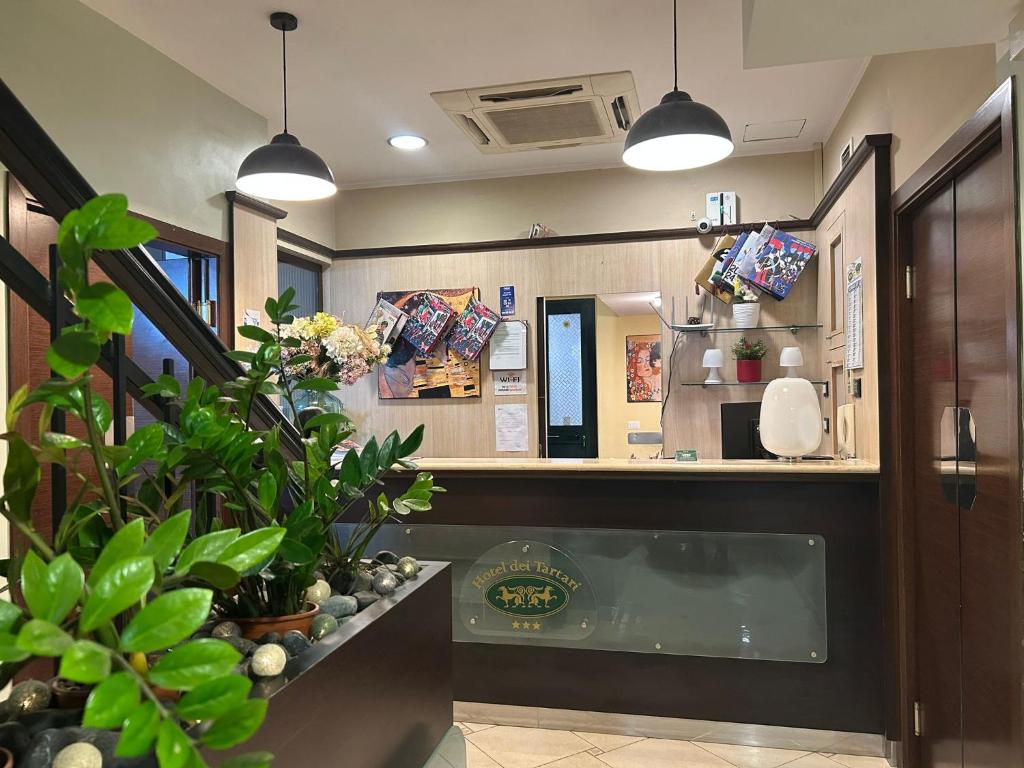 a restaurant with a counter with potted plants at Hotel Dei Tartari in Guidonia