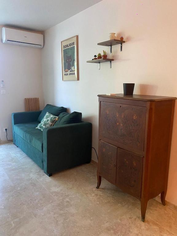 een woonkamer met een bank en een houten dressoir bij Cozy, fully renovated studio in Marigot