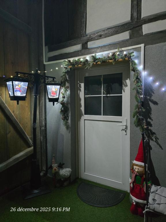 a white door with a christmas garland on it at Atelier d Antoine in Saasenheim