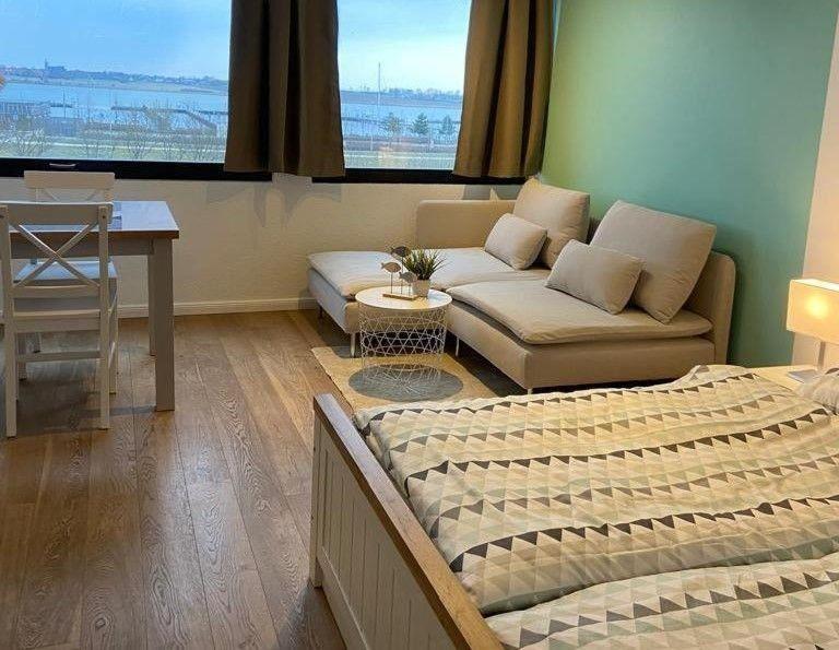 a living room with a bed and a couch at Kaept-ns-Inn in Burgtiefe auf Fehmarn 