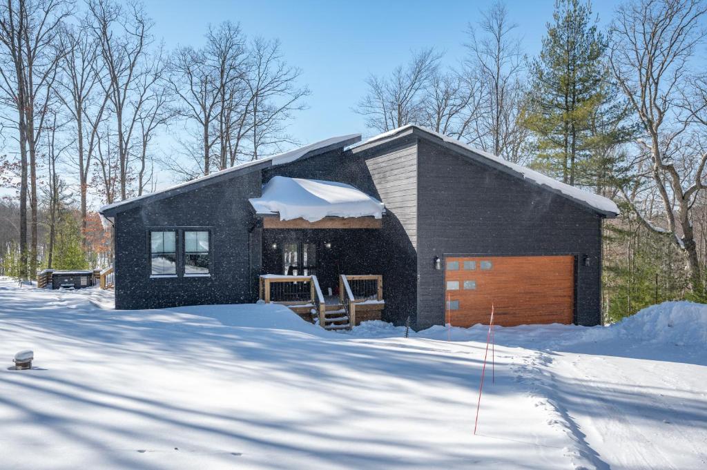 a black house with a garage in the snow at Bourbon Sunset by Railey Vacations in Swanton