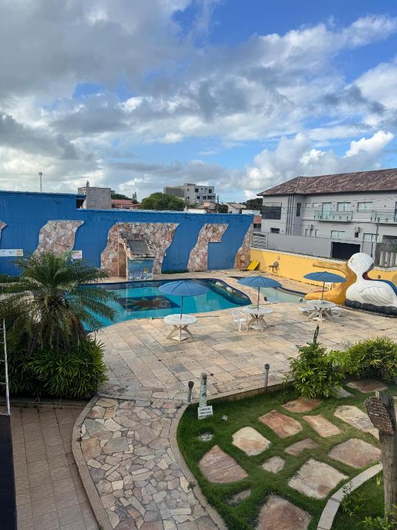 a large swimming pool with a blue building at Pousada Refúgio da Ilha in São Mateus