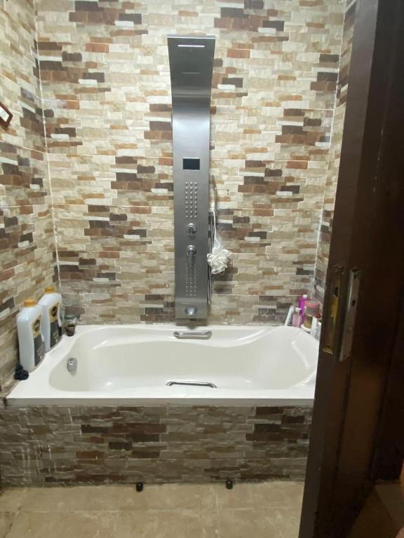 a bath tub in a bathroom with a tile wall at المناره هاوس in Wadi Musa